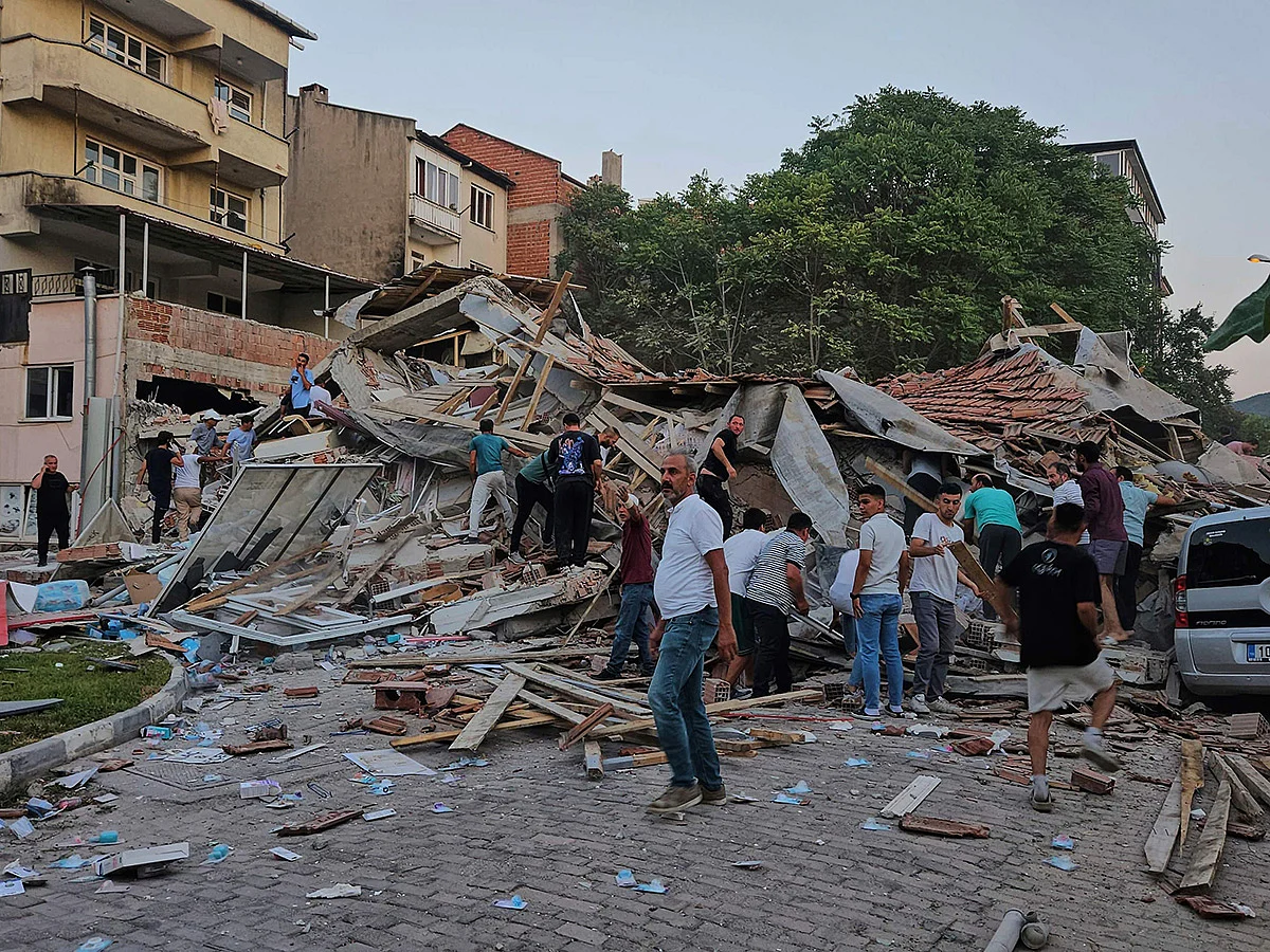 People remove the wreckage of a collapsed building following an earthquake in Sindirgi, northwest Turkey.