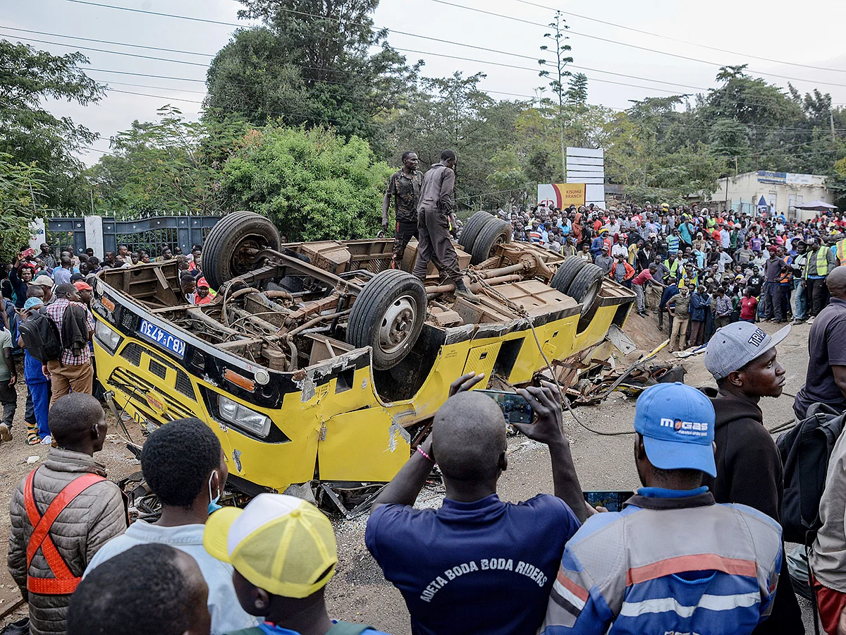 People gather at the scene of a bus accident that overturned, killing several people, in Kisumu, Kenya, on Friday, August 8, 2025. 