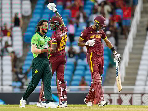Hasan Ali (L) of Pakistan walks off the field while Justin Greaves (C) and Roston Chase (R) of West Indies celebrate winning the second ODI at Brian Lara Cricket Academy in Tarouba, San Fernando, Trinidad and Tobago on August 10, 2025.   
