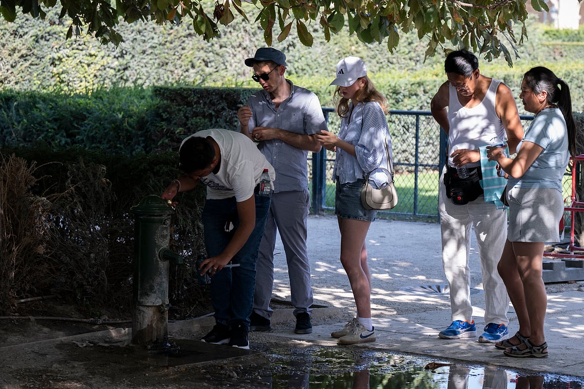 Visitors queue at a public water fountain at the Jardin du Carrousel in Paris amid a heatwave in Europe.