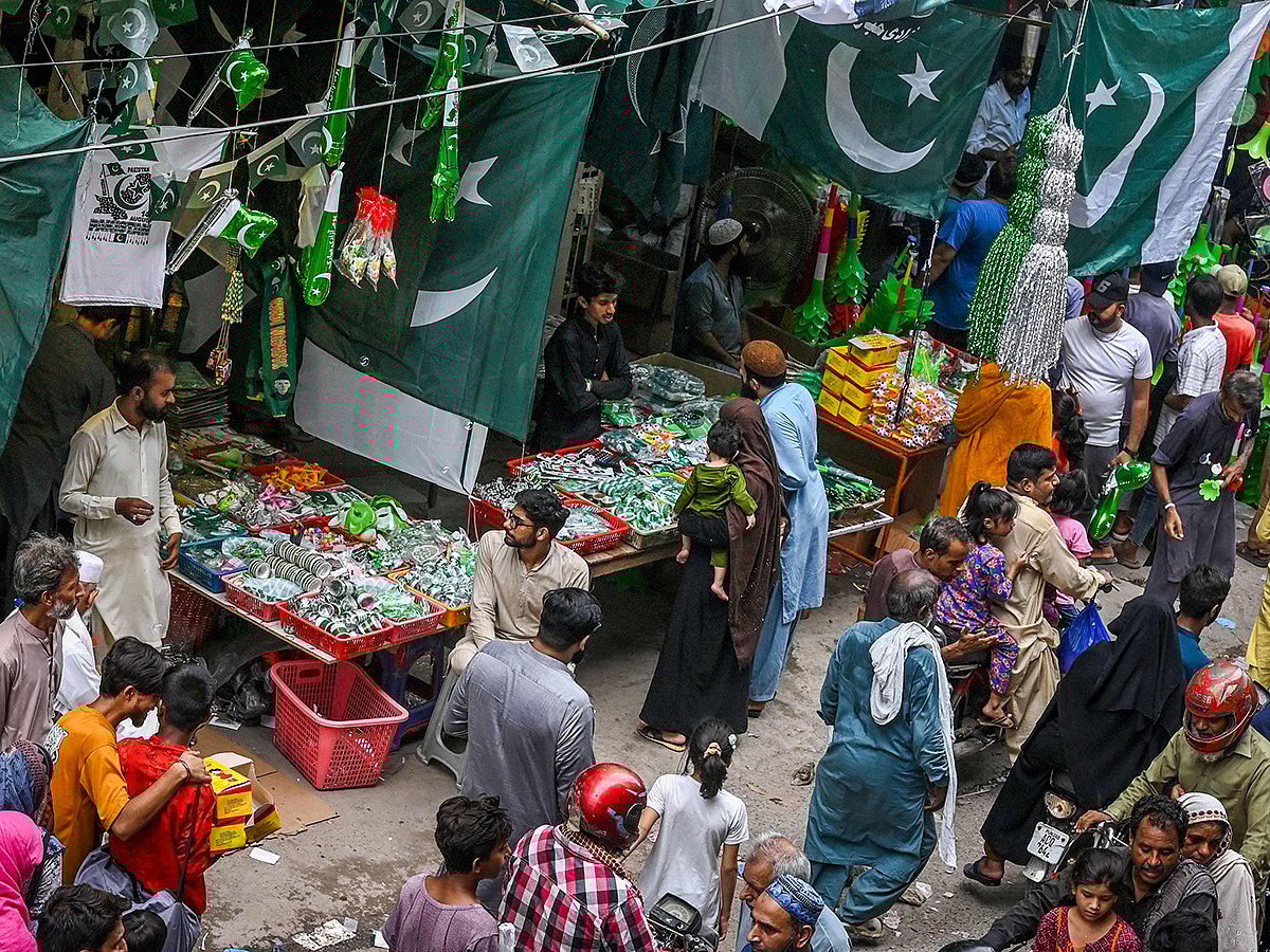 People crowd a marketplace with shops selling Pakistan's national flags and other items ahead of the country's Independence Day celebrations in Lahore on August 10, 2025. 