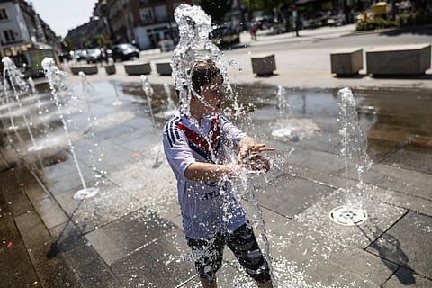 A child cools off himself at a fountain in Place d'Armes in Calais, northern France on August 12, 2025, amid a heatwave in Europe. A heatwave swept through parts of Europe, breaking temperature records at weather stations in southern France and sparking wildfire risks while Bulgaria battled nearly 200 blazes.