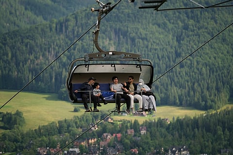 A rainy day in Zakopane might not thrill most tourists—but for visitors from the Gulf, it’s a welcome break from 50°C heat. Nestled at the base of the Tatras, Poland’s highest mountain range, the alpine-style town of Zakopane has become an unexpected summer hotspot for tourists from the United Arab Emirates, Saudi Arabia and Kuwait. Above, tourists sit in a chairlift on the hill Gubalowka, a mountain from which there is a view of Zakopane and the Tatra Mountains.
