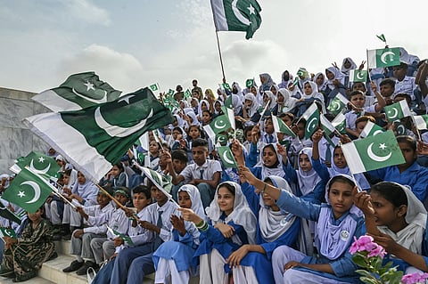 Students wave Pakistan's national flags during Independence Day celebrations at the mausoleum of the country's founding father, Muhammad Ali Jinnah, in Karachi on August 14, 2025.