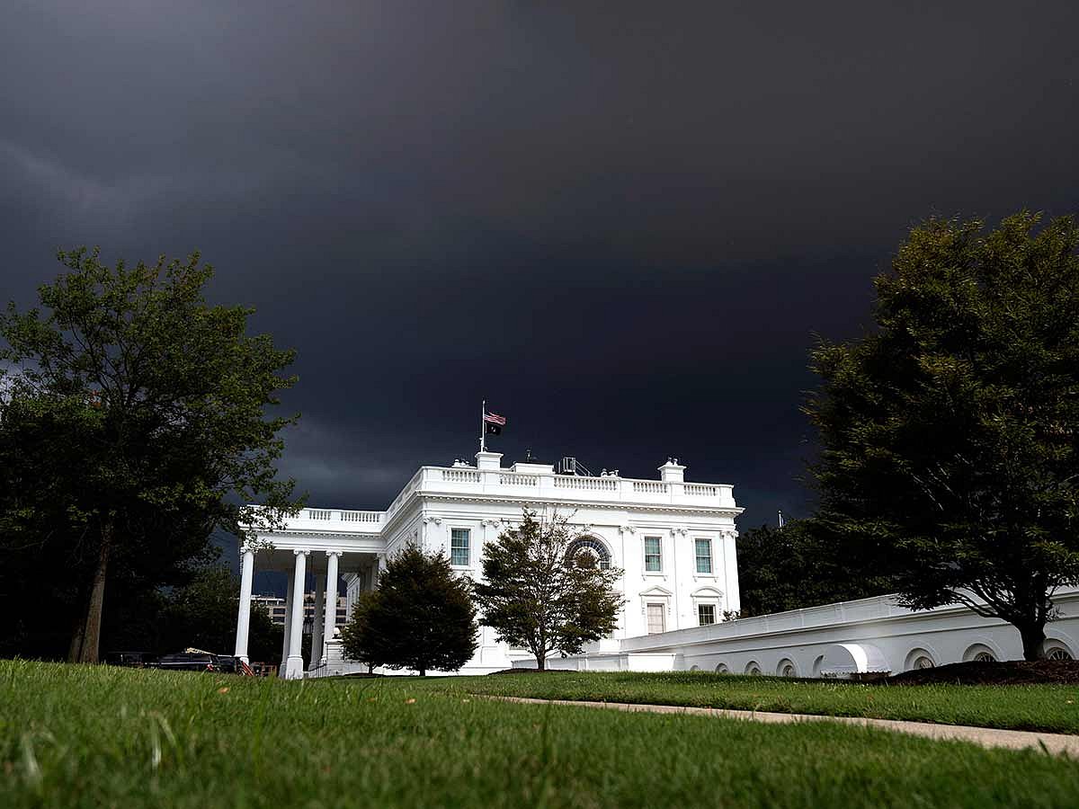 Dark clouds are seen in the sky behind the White House, on August 14, 2025, in Washington. 