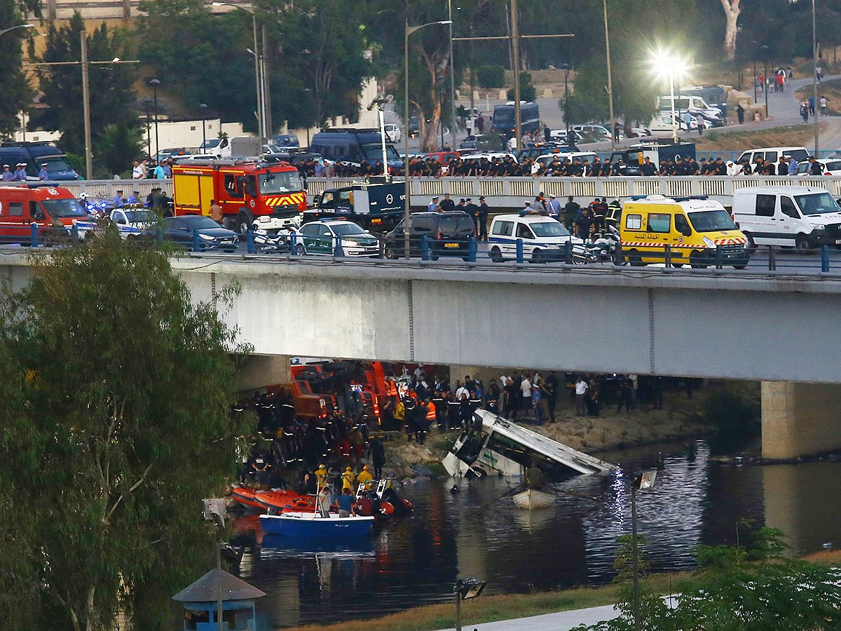 Rescue workers operate after a passenger bus plunged into a river, killing at least 18 people, on Friday, August 15, 2025 in the El Harrach district of Algiers. 