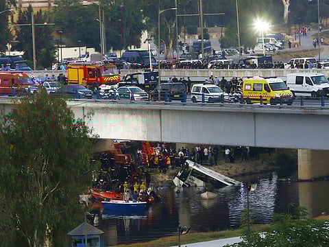 Rescue workers operate after a passenger bus plunged into a river, killing at least 18 people, on Friday, August 15, 2025 in the El Harrach district of Algiers. 