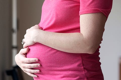 A pregnant woman stands for a portrait in Dallas, May 18, 2023. Photo used for illustrative purposes.