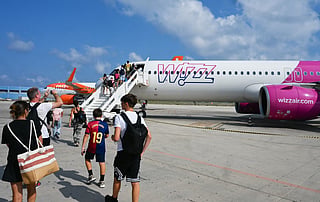 Passengers embark aboard a Wizz air jet at the Lampedusa airport. Wizz Air has announced plans to bring back flights to Dubai, Abu Dhabi, Jeddah and Amman, with 12 routes and 49 weekly flights.