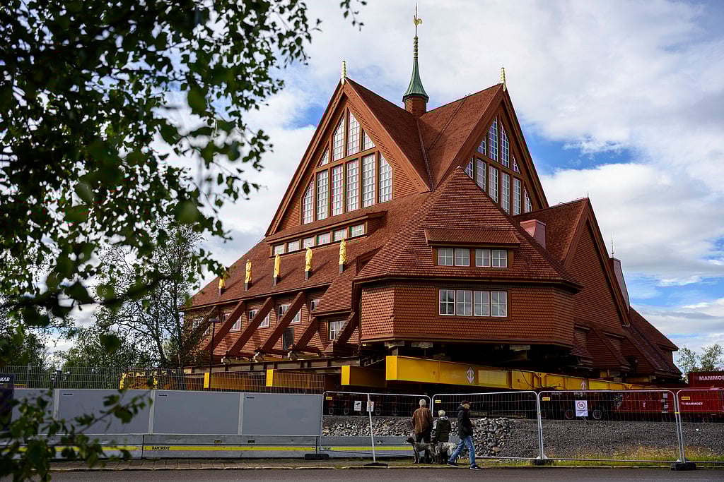 People look at the Kiruna Church, a Sami style wooden Swedish Lutheran church, called Kiruna Kyrka in Swedish, in Kiruna, Sweden, Monday, Aug. 18, 2025, a day before it will be moved along a 5-kilometre route east to a new city centre as part of the town's relocation. 