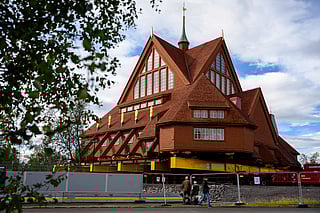 People look at the Kiruna Church, a Sami style wooden Swedish Lutheran church, called Kiruna Kyrka in Swedish, in Kiruna, Sweden, Monday, Aug. 18, 2025, a day before it will be moved along a 5-kilometre route east to a new city centre as part of the town's relocation. 