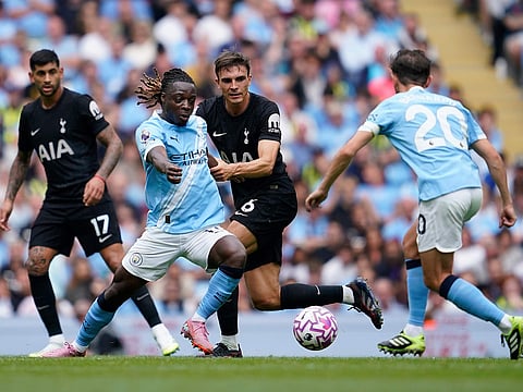Manchester City's Jeremy Doku, left, and Tottenham's Joao Palhinha fight for the ball during the Premier League soccer match in Manchester, England, on Saturday, August 23, 2025. 