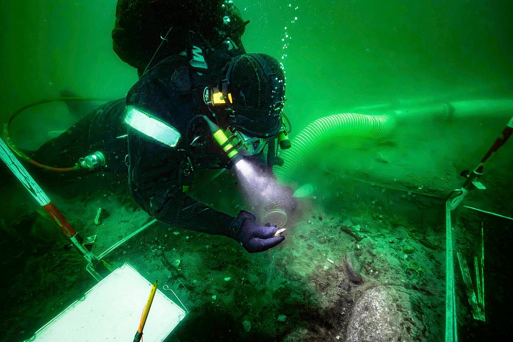 A diver excavates an 8,500-year-old Stone Age coastal settlement, submerged by sea level rise in the Bay of Aarhus, Denmark.