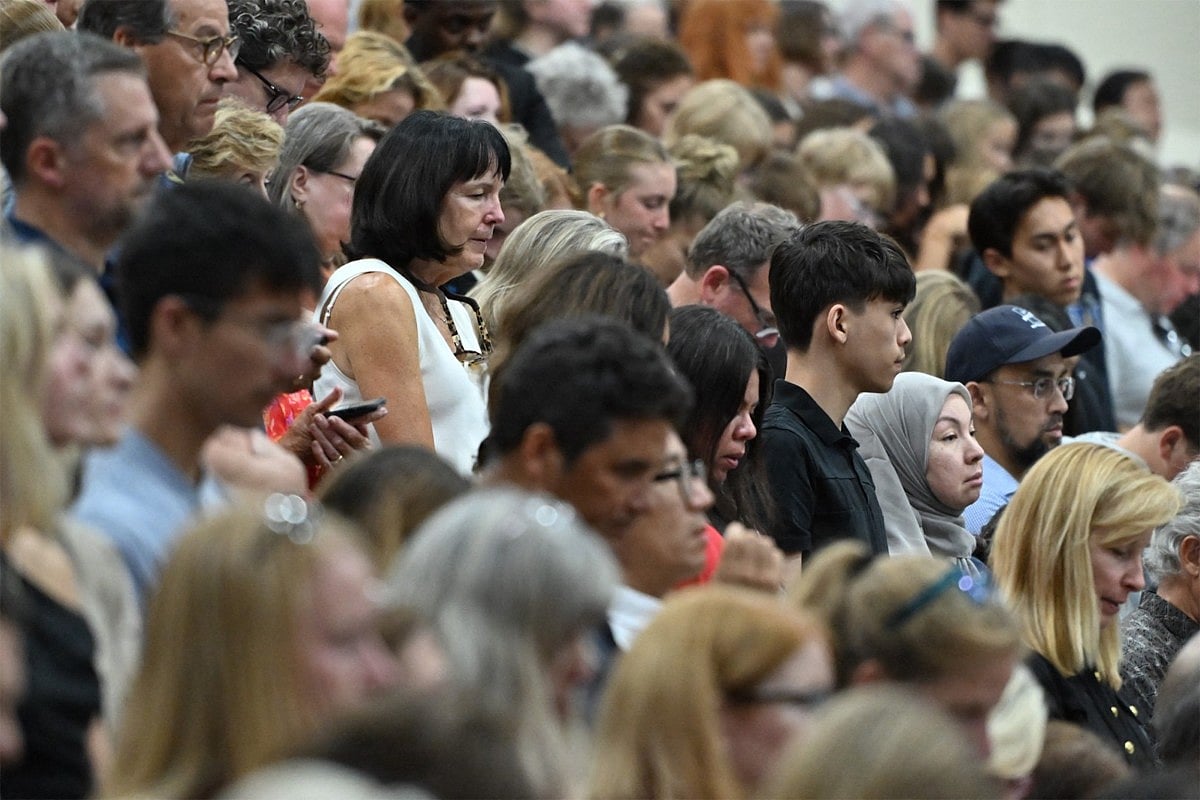 People attend at a vigil at Academy of Holy Angels in Richfield, Minnesota, for the victims of a mass shooting at Annunciation Catholic Church and School in Minneapolis.