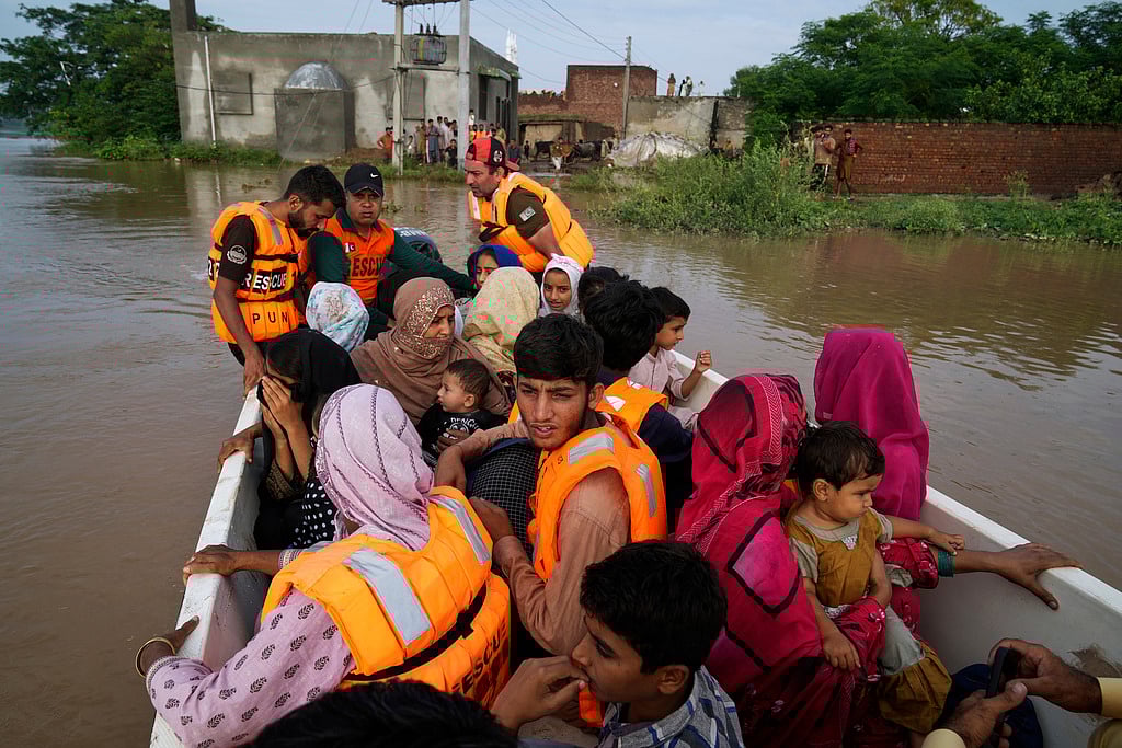 Rescue workers evacuate villagers from a flooded area in Chango Walia village in Narowal district, Pakistan, August 27, 2025.  