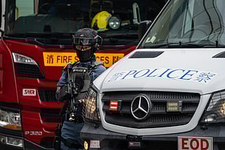 A Hong Police police officer stands guard next to a police van during an exercise in Hong Kong. File photo taken on August 28, 2025.