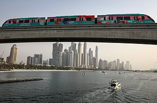 A train runs over a section of Dubai's Palm Monorail, with a backdrop of the city's high rise buildings