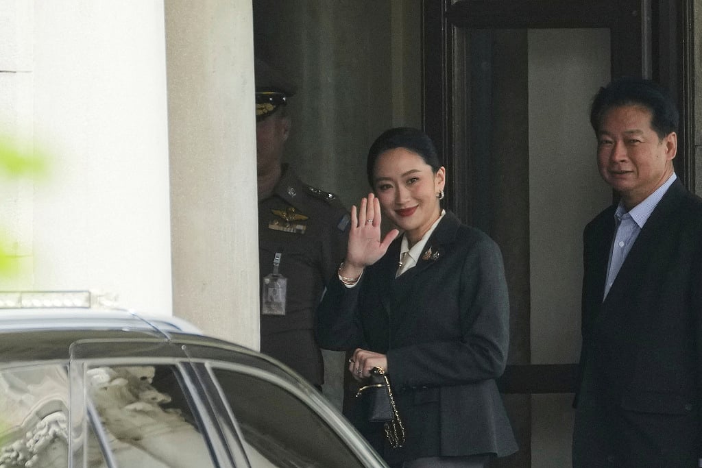 Thailand's suspended Prime Minister Paetongtarn Shinawatra, center, arrives at Government House in Bangkok, Thailand, Friday, Aug. 29, 2025. (AP Photo/Sakchai Lalit)