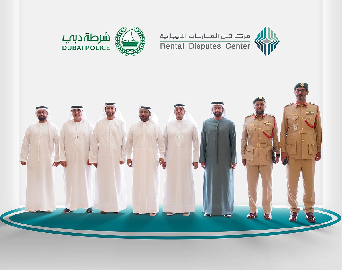 Officials from Dubai Police and the Rental Dispute Committee standing for a photograph after a meeting in Dubai