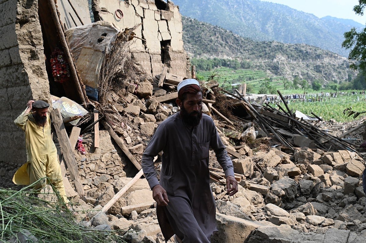 An Afghan man walks past a damaged house following earthquakes in the Mazar Dara village of Nurgal, a district of the Kunar Province, in Eastern Afghanistan, on September 1, 2025.