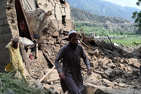 An Afghan man walks past a damaged house following earthquakes in the Mazar Dara village of Nurgal, a district of the Kunar Province, in Eastern Afghanistan, on September 1, 2025.