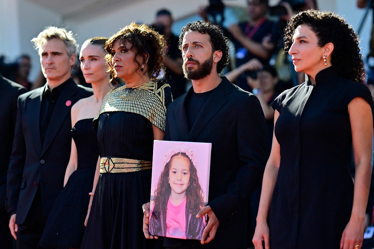 From left : US actor Joaquin Phoenix, US actress Rooney Mara, Tunisian director Kaouther Ben Hania, actor Motaz Malhees and actress Clara Khoury pose with a portrait of late Palestinian girl Hind Rajab during the red carpet for the movie "The Voice of Hind Rajab" presented in competition at the 82nd International Venice Film Festival, at Venice Lido on September 3, 2025.