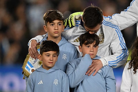 Argentina's forward #10 Lionel Messi hugs his sons ahead of the 2026 FIFA World Cup South American qualifiers football match between Argentina and Venezuela at the Mas Monumental stadium in Buenos Aires on September 4, 2025.