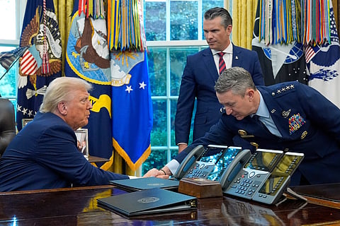 President Donald Trump shakes hands with Chairman of the Joint Chiefs of Staff Gen. Dan Caine as Defence Secretary Pete Hegseth watches in the Oval Office of the White House.