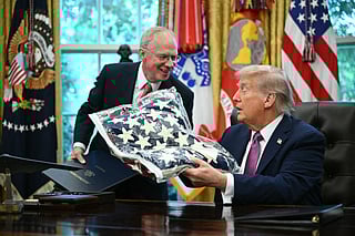 US President Donald Trump (R) receives a flag from US Representative John Rose, Republican of Tennessee, while signing executive orders in the Oval Office of the White House in Washington, DC on September 5, 2025.