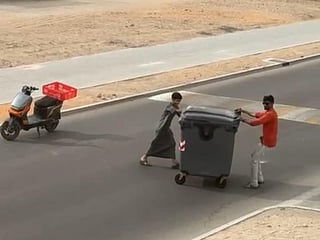 Watch: Emirati boy, resident push bin off busy UAE road