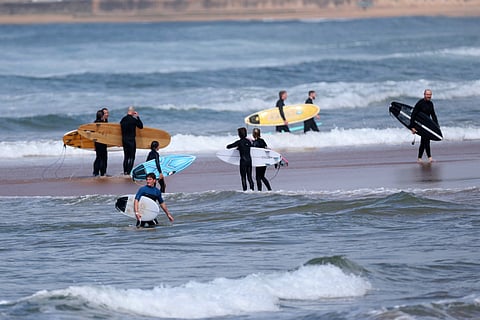 Surfers exit the water after authorities closed Long Reef Beach in Sydney following a shark attack on September 6, 2025.