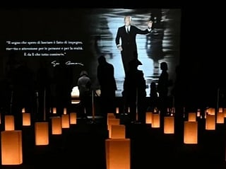 People queue to see the coffin of late Italian fashion designer Giorgio Armani lying-in state for two days at the Armani Theatre in Milan as a picture of him is seen on a screen, on September 6, 2025.