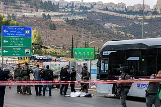 Israeli security forces gather by a body next to a bus at the Ramot road junction in Israeli-annexed east Jerusalem on September 8, 2025.
