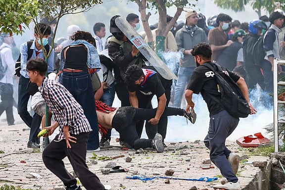 Demonstrators carry an injured victim during a protest outside the Parliament in Kathmandu on September 8, 2025, held to condemn the government over social media prohibitions and corruption.  