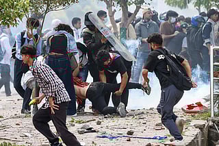 Demonstrators carry an injured victim during a protest outside the Parliament in Kathmandu on September 8, 2025, held to condemn the government over social media prohibitions and corruption.  