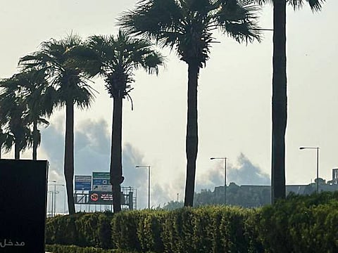 A man looking at smoke billowing after explosions in Doha's capital Qatar.