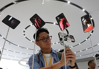 An attendee takes a video of a display of new Apple iPhone 17 Pros during an Apple special event at Apple headquarters on September 9, 2025 in Cupertino, California.