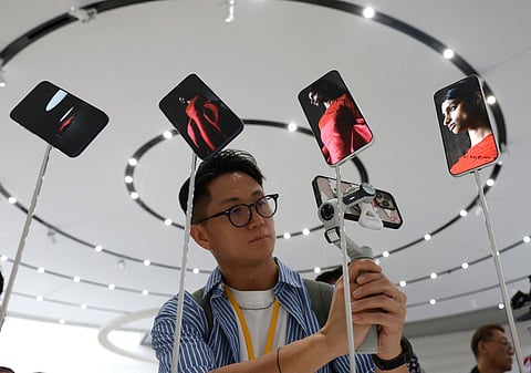 An attendee takes a video of a display of new Apple iPhone 17 Pros during an Apple special event at Apple headquarters on September 9, 2025 in Cupertino, California.