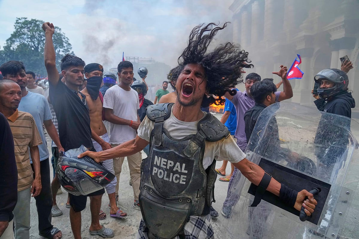 A protester wearing a flak jacket and carrying a shield seized from police shouts slogans outside Singha Durbar, the administrative hub of Nepal’s government, during demonstrations against a social media ban and corruption in Kathmandu on Sept. 9, 2025.