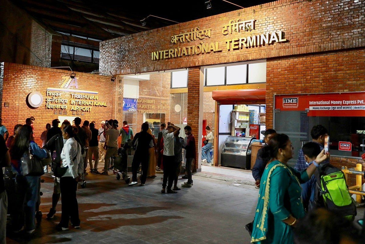 Passengers gather at an entrance of Tribhuvan International Airport after it reopened in Kathmandu on September 10, 2025, following a closure due to civil unrest in Nepal's capital.