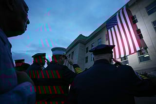 Members of the military and first responders watch as an American flag is unfurled on the side of the Pentagon to commemorate the 24th anniversary of the 9/11 terror attacks on September 11, 2025 in Arlington, Virginia.