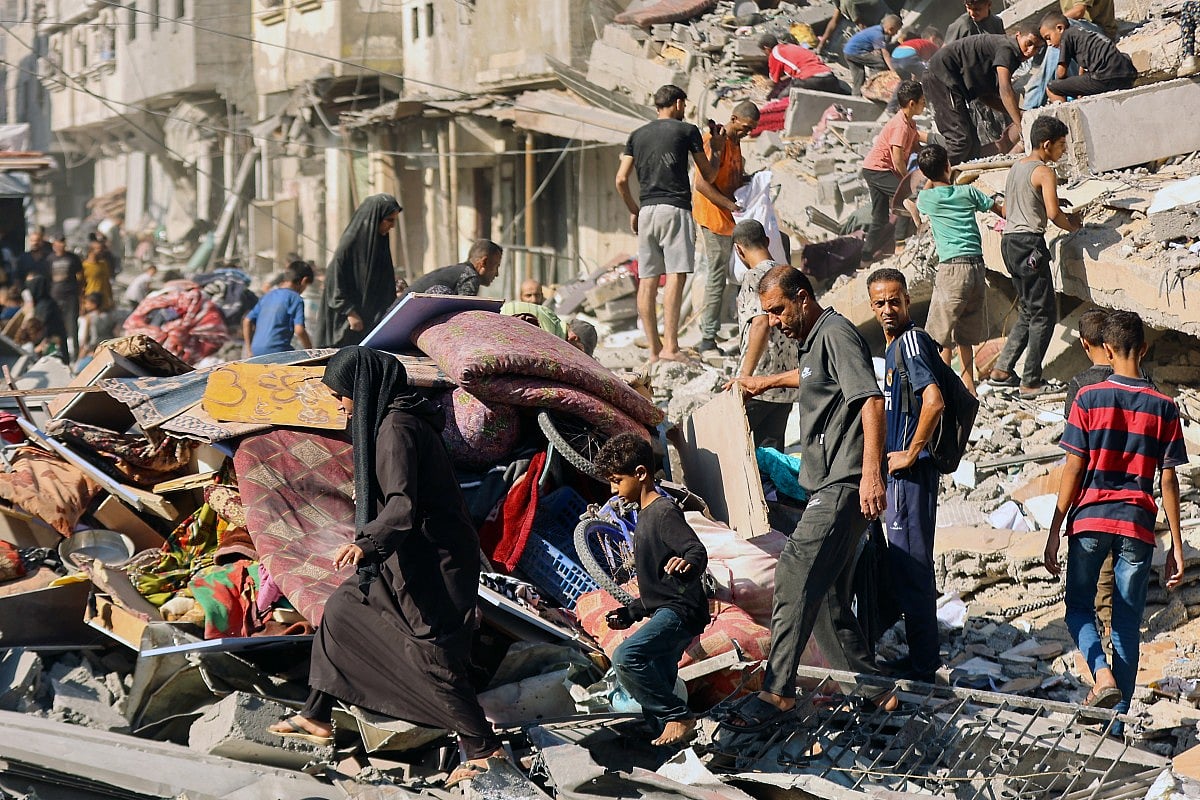 Palestinians retrieve items from the rubble of a destroyed building following overnight Israeli army bombardment on al-Shati camp for Palestinian refugees, west of Gaza City, on September 12, 2025.