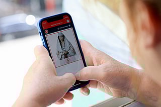 A woman looks at a phone as she uses the Albanian government portal "E - Albania", now assisted by government artificial intelligence cabinet minister avatar "Diella", in Tirana on September 12, 2025.