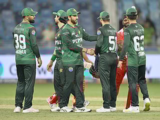 Pakistan's captain Salman Ali Agha (2nd-left) shakes hand with his teammates after winning the Asia Cup 2025 T20 match against Oman at the Dubai International Stadium in Dubai on September 12, 2025. 