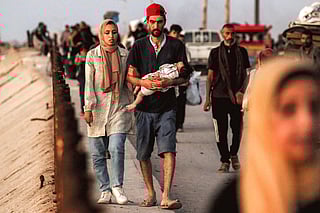 Displaced Palestinians evacuating southbound from Gaza City along the coastal road in Nuseirat in the central Gaza Strip on September 13, 2025.  