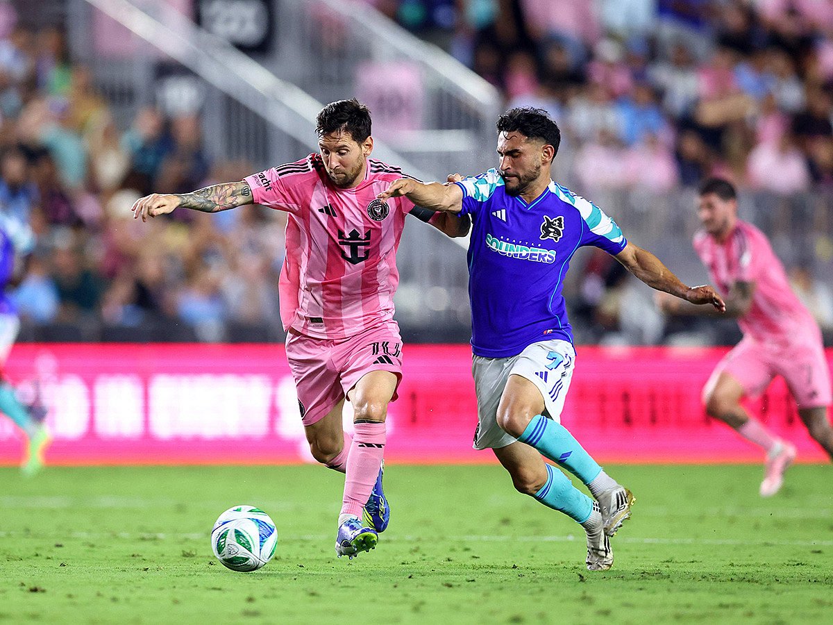Lionel Messi #10 of Inter Miami CF is challenged by Cristian Roldan #7 of the Seattle Sounders FC during the MLS match between Inter Miami CF and Seattle Sounders FC at Chase Stadium.
