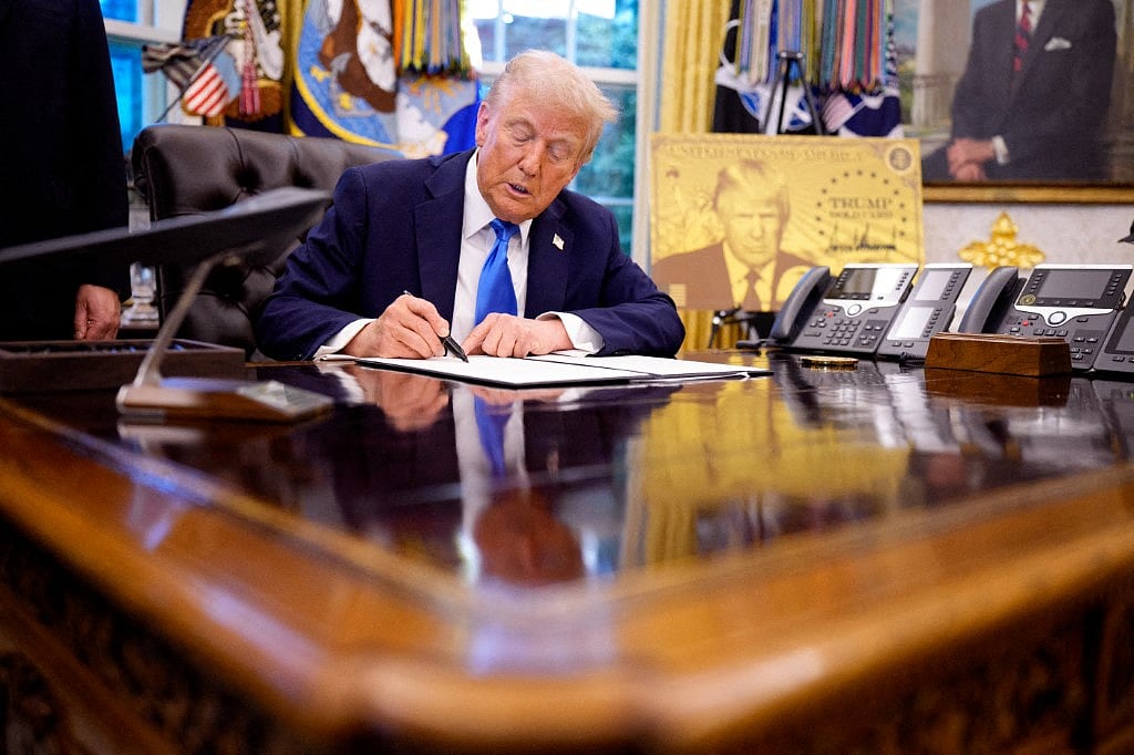President Donald Trump signs an executive order in the Oval Office at the White House on September 19, 2025 in Washington, DC. Trump signed two executive orders, establishing the "Trump Gold Card" and introducing a $100,000 fee for H-1B visas.