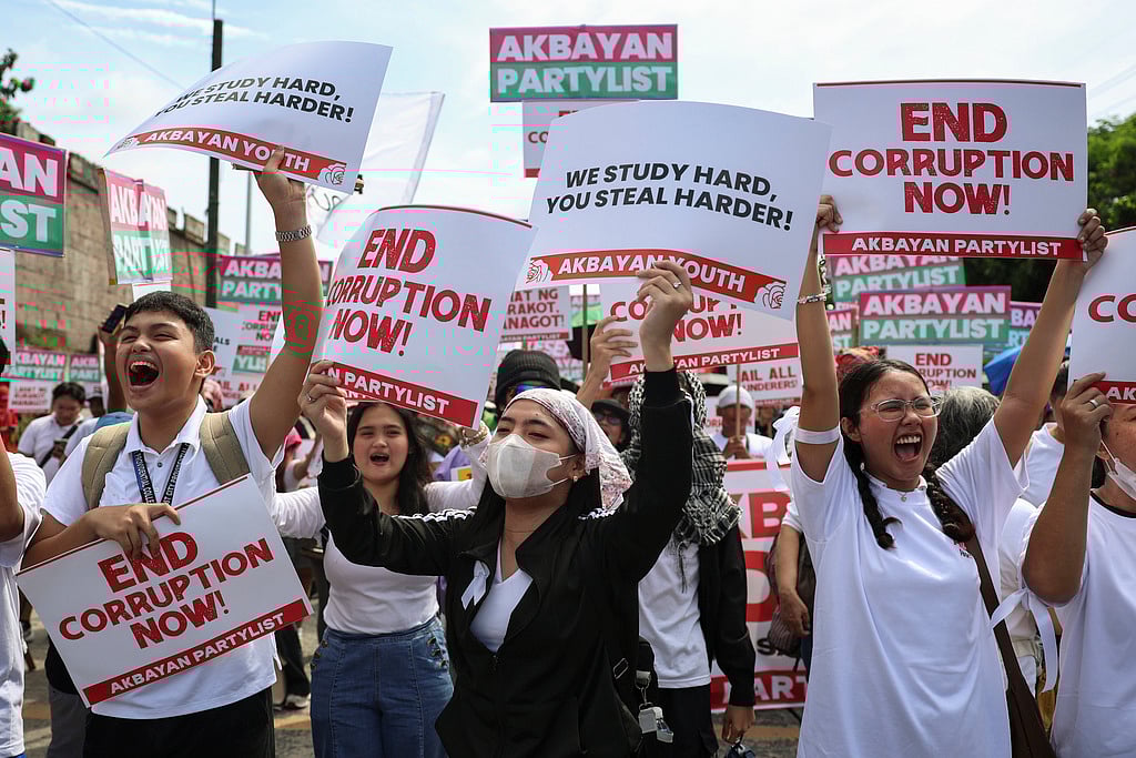Protesters carry signs as they gather during a rally against government corruption at the EDSA People Power Monument in suburban Mandaluyong, east of Manila, Philippines, Sunday. Sept. 21, 2025. 