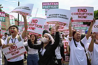 Protesters carry signs as they gather during a rally against government corruption at the EDSA People Power Monument in suburban Mandaluyong, east of Manila, Philippines, Sunday. Sept. 21, 2025. 
