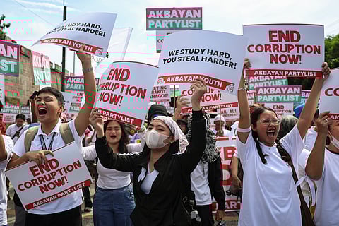 Protesters carry signs as they gather during a rally against government corruption at the EDSA People Power Monument in suburban Mandaluyong, east of Manila, Philippines, Sunday. Sept. 21, 2025. 